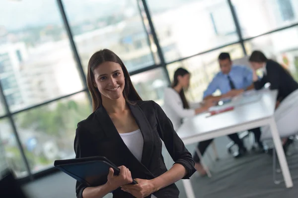 Mujer de negocios con su personal en segundo plano en la oficina — Foto de Stock