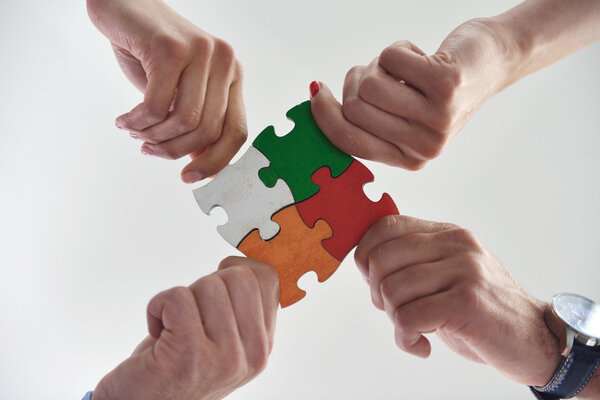 Group of business assembling jigsaw puzzle