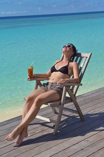 Красива молода жінка з випивкою біля моря — стокове фото