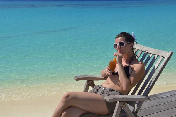 Beautiful young woman with a drink by the sea — Stock Photo, Image