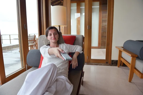 Glückliche junge Frau entspannt sich zu Hause auf dem Sofa — Stockfoto