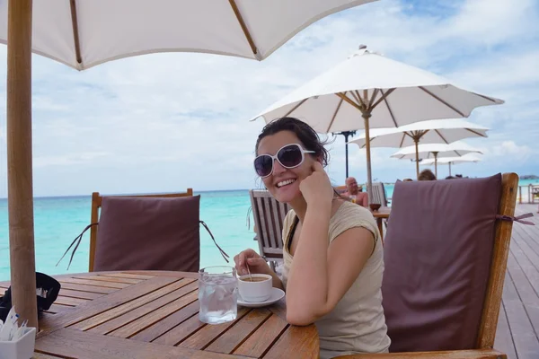 Hermosa joven con una bebida junto al mar —  Fotos de Stock