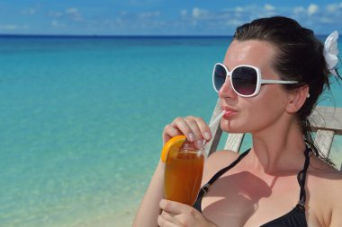 Deniz kenarında bir içkiyle güzel genç kadın