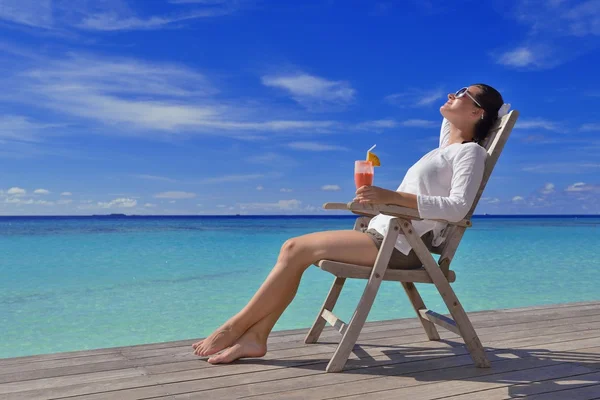 Mooie jonge vrouw met een drankje bij de zee — Stockfoto