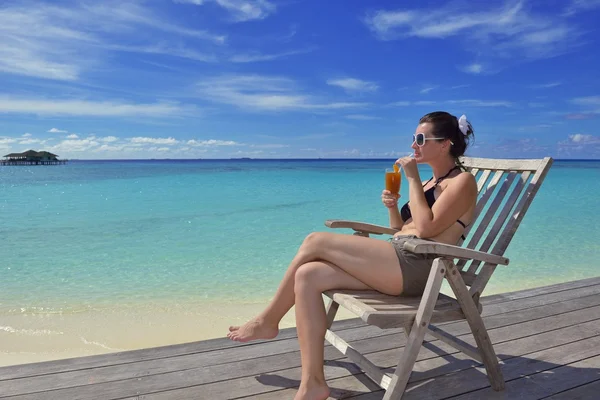 Bella giovane donna con un drink al mare — Foto Stock