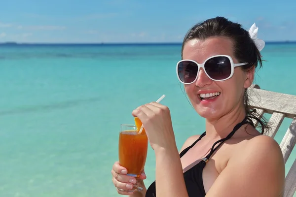 Beautiful young woman with a drink by the sea — Stock Photo, Image