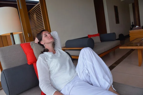 Jovem feliz relaxar em casa no sofá — Fotografia de Stock