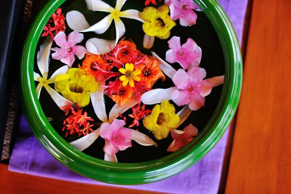 Tazza d'acqua con bellissimi fiori sfondo — Foto Stock