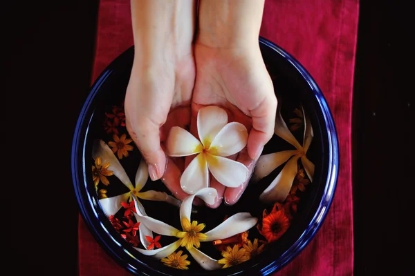 Mano femminile e fiore in acqua — Foto Stock