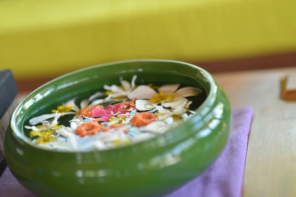 Water cup with beautiful flowers background — Stock Photo, Image