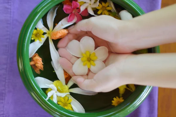 Female hand and flower in water — Stock Photo, Image