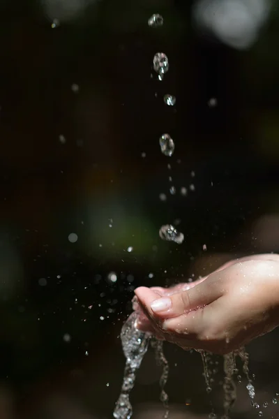 Corriente de agua en la mano mujer — Foto de Stock
