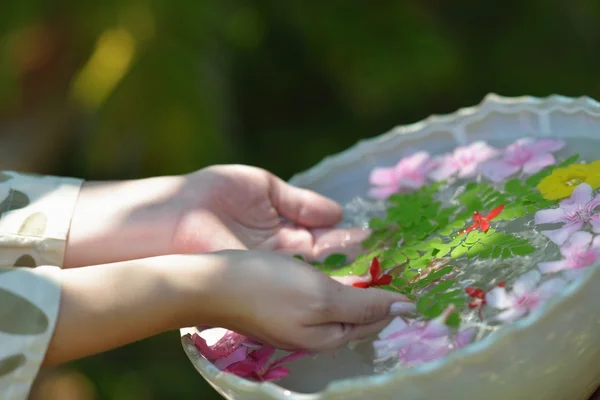 Kvinnlig hand och blomma i vatten — Stockfoto