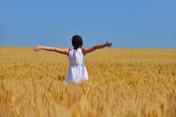 Jovem mulher no campo de trigo no verão — Fotografia de Stock