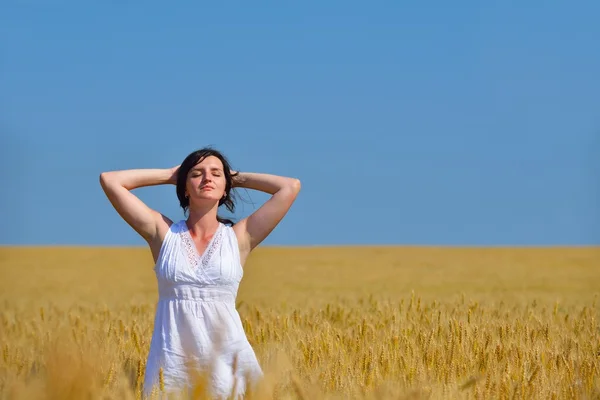 Junge Frau im Weizenfeld im Sommer — Stockfoto