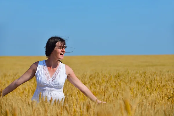 Mujer joven en el campo de trigo en verano — Foto de Stock