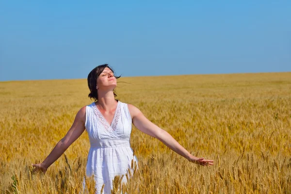 Junge Frau im Weizenfeld im Sommer — Stockfoto