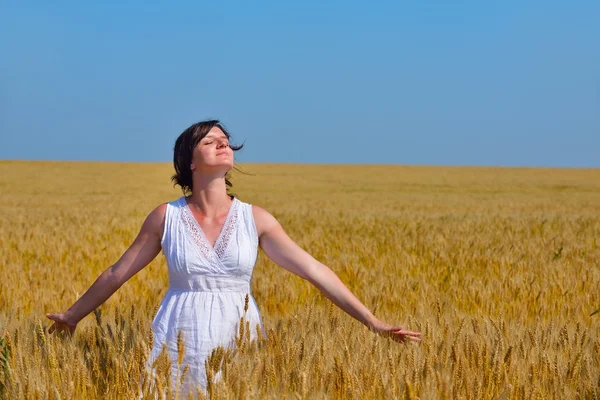 Junge Frau im Weizenfeld im Sommer — Stockfoto