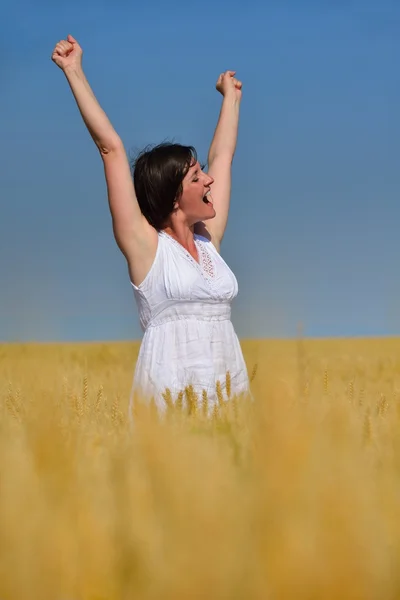 Jonge vrouw in tarweveld in de zomer — Stockfoto