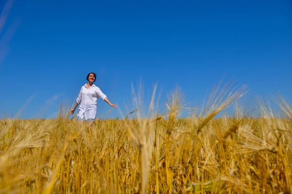 Junge Frau im Weizenfeld im Sommer — Stockfoto