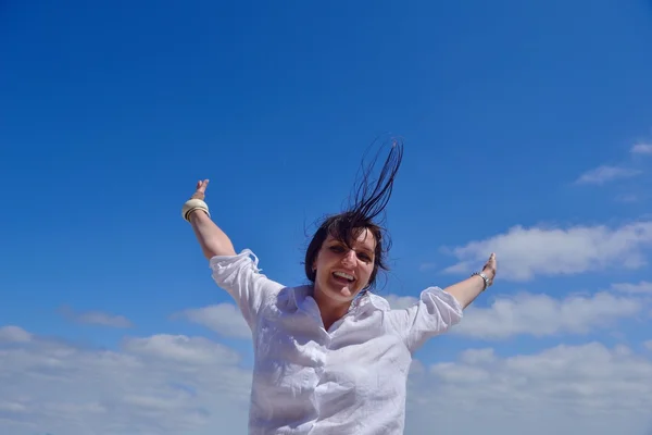 Mujer joven con brazos extendidos al cielo — Foto de Stock