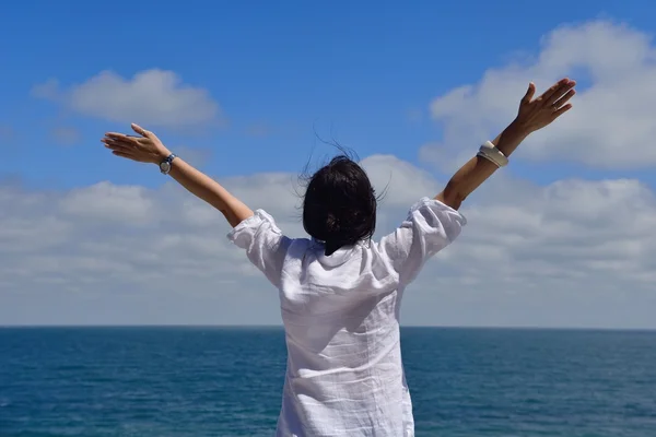 Young woman with spreading arms to sky — Stock Photo, Image