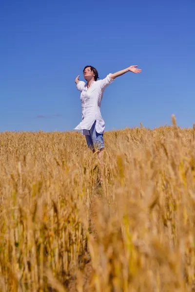 Junge Frau im Weizenfeld im Sommer — Stockfoto