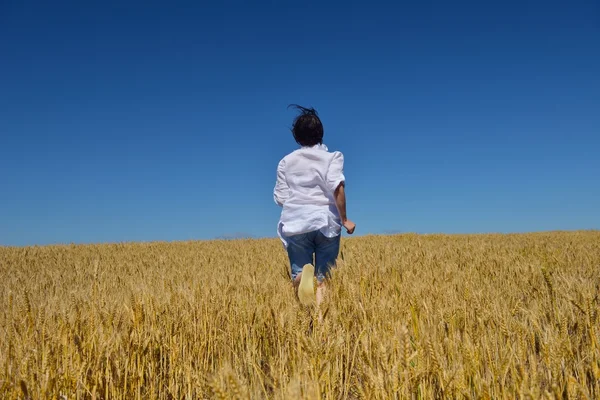 Νεαρή γυναίκα στον αγρό σιταριού το καλοκαίρι — Φωτογραφία Αρχείου
