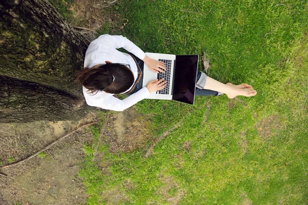 Vrouw met laptop in park — Stockfoto