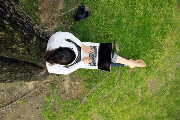 Mujer con portátil en el parque —  Fotos de Stock