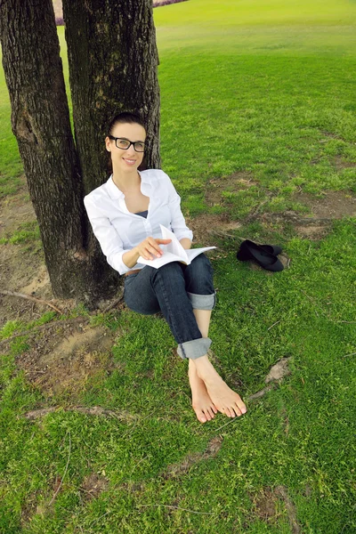 Mujer joven leyendo un libro en el parque — Foto de Stock