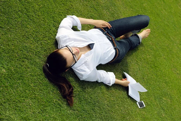 Ung kvinna läser en bok i parken — Stockfoto