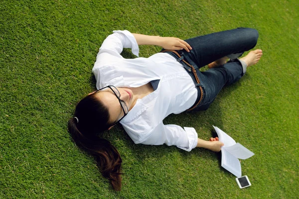 Jonge vrouw leest een boek in het park — Stockfoto