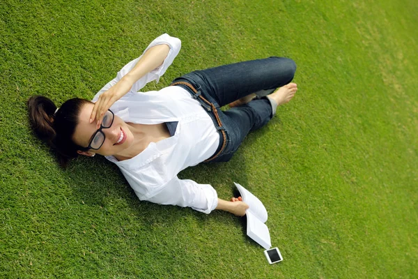 Giovane donna che legge un libro nel parco — Foto Stock