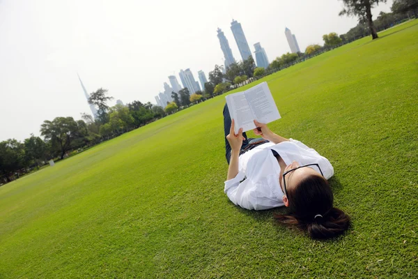 Mladá žena čte knihu v parku — Stock fotografie