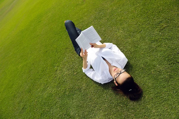 Jeune femme lisant un livre dans le parc — Photo