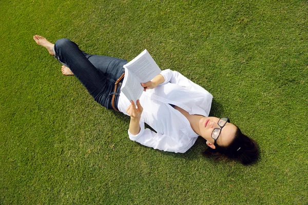 Jeune femme lisant un livre dans le parc — Photo