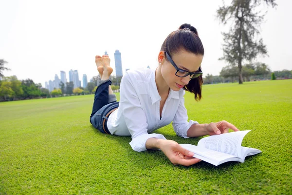 Genç bir kadın parkta kitap okuyor. — Stok fotoğraf