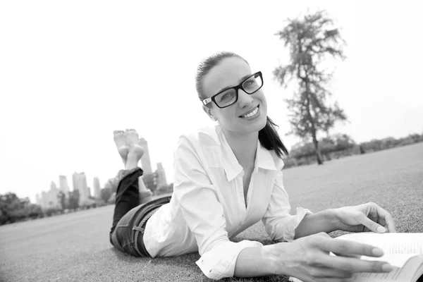 Junge Frau liest im Park ein Buch — Stockfoto