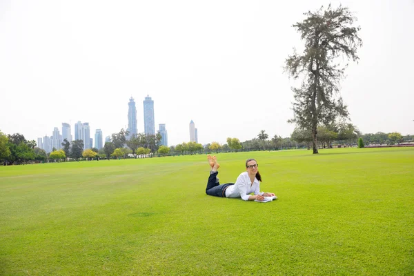 Mujer joven leyendo un libro en el parque —  Fotos de Stock