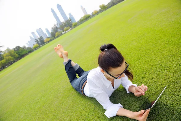 Mooie jonge vrouw met tablet in park — Stockfoto