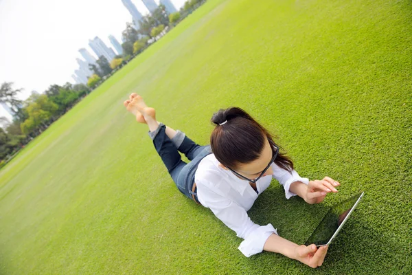 Mooie jonge vrouw met tablet in park — Stockfoto