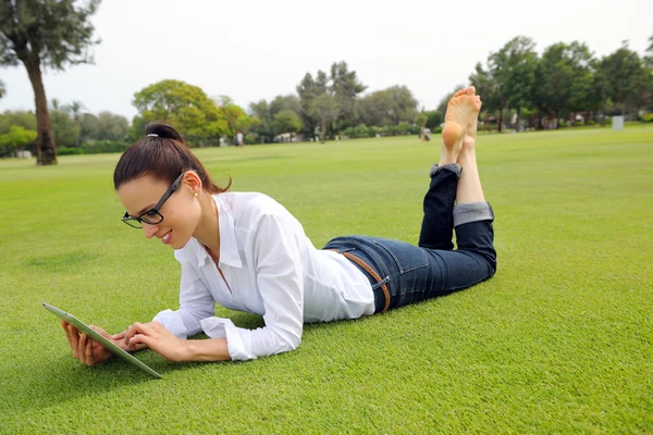 Bella giovane donna con tablet nel parco — Foto Stock