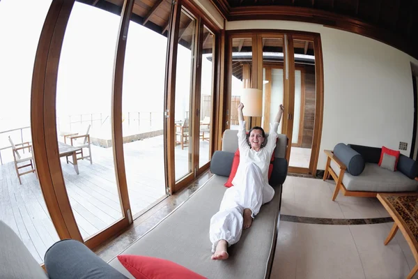 Jovem feliz relaxar em casa no sofá — Fotografia de Stock