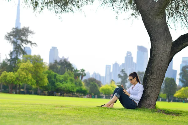 Hermosa joven con tableta en el parque — Foto de Stock