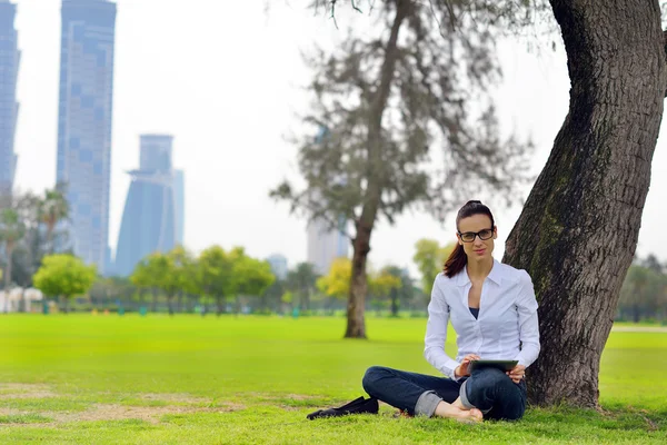 Schöne junge Frau mit Tablet im Park — Stockfoto