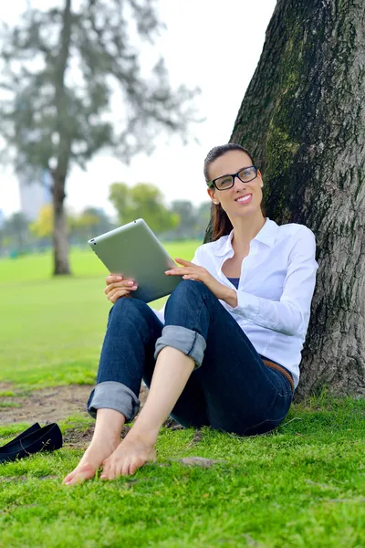 Beautiful young woman with tablet in park — Stock Photo, Image