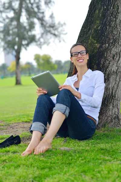 Tablet Park ile güzel bir genç kadın — Stok fotoğraf