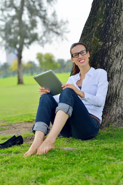 Tablet Park ile güzel bir genç kadın — Stok fotoğraf