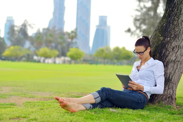 Mooie jonge vrouw met tablet in park — Stockfoto